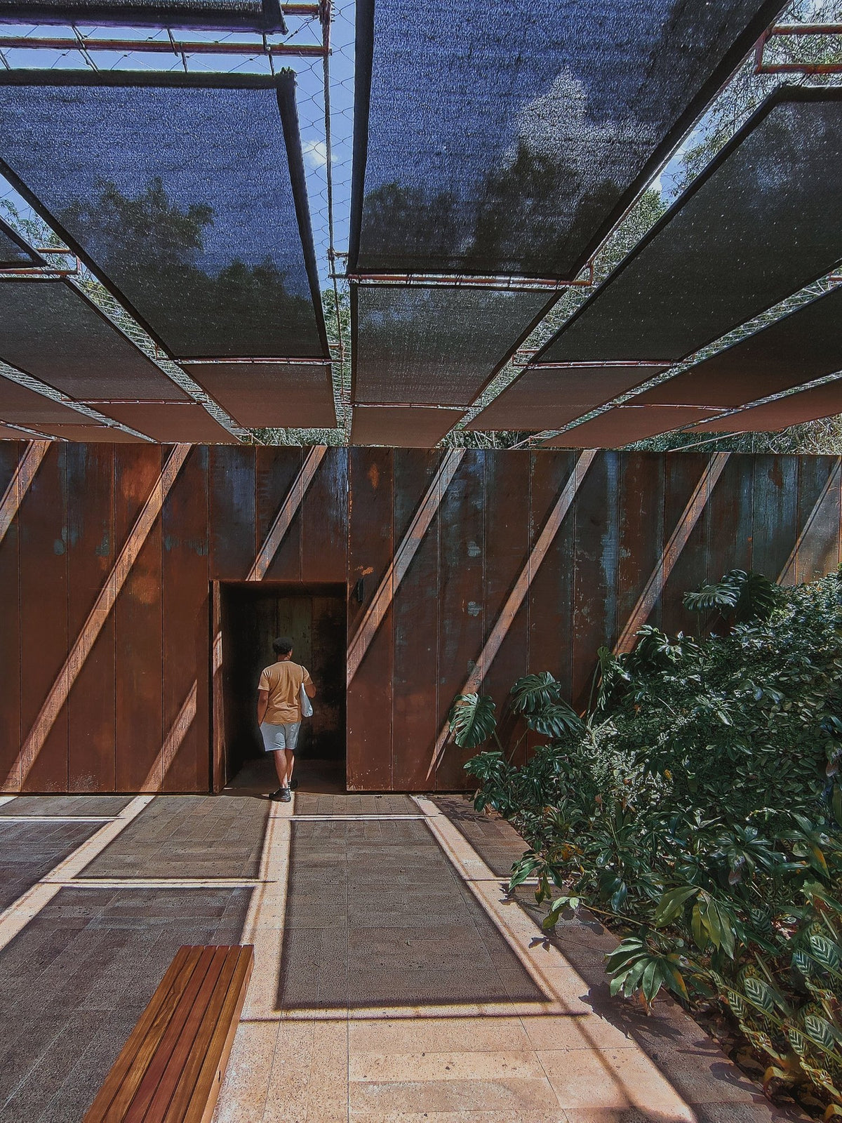 Overhead shade cloth panels covering an outdoor courtyard.
